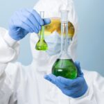 front-view-scientist-holding-green-chemicals front-view-scientist-holding-green-chemicals